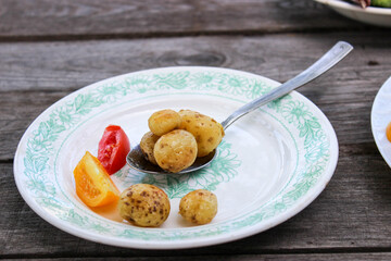 Round new potatoes fried to Golden brown with tomatoes, herbs and lettuce
