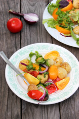 Round new potatoes fried to Golden brown with tomatoes, herbs and lettuce