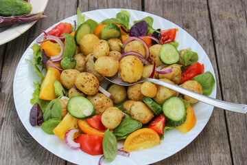 Round new potatoes fried to Golden brown with tomatoes, herbs and lettuce