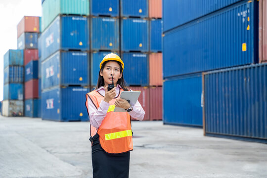 Contenner woman worker with laptop checking position loading containers box,Large container shipping at shipping yard main transportation of cargo container shipping