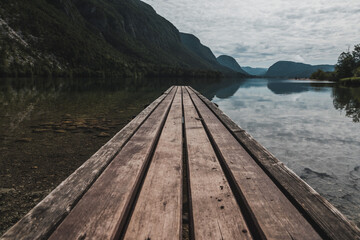 Wooden pier on lake mountain Bohinj, Slovenia with a great view of the lake and surrounding mountains