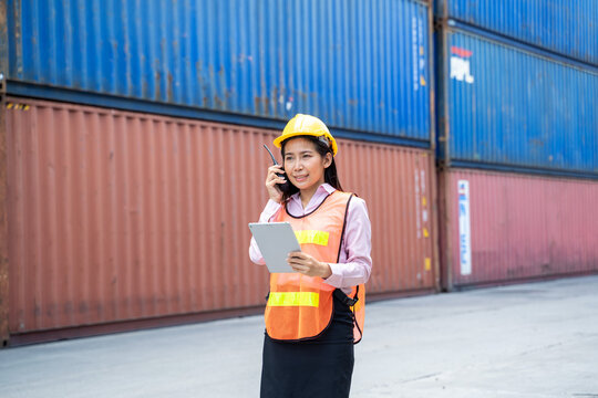 Contenner woman worker with laptop checking position loading containers box,Large container shipping at shipping yard main transportation of cargo container shipping