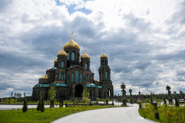 Fototapeta na wymiar panoramic view of a dark temple with golden domes against a background of gray clouds