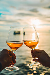 couple resting on sunset at sea beach and drinking wine