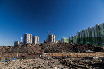 Fototapeta na wymiar New apartment houses near piles of dirt