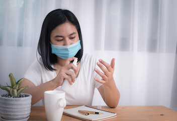 Asian young woman wearing mask and spray alcohol bottle to protect from coronavirus epidemic