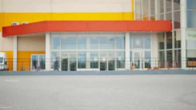 Side view of empty grocery cart moving in parking lot near shopping mall