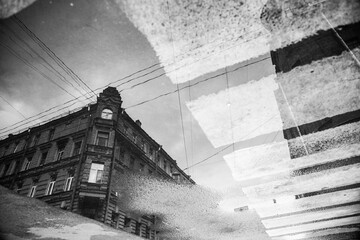Old vintage house reflected in a dirty puddle