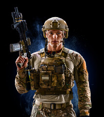 Army soldier in Protective Combat Uniform holding Special Operations Forces Combat Assault Rifle on...