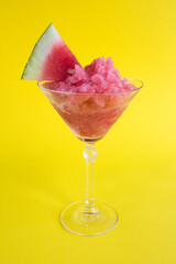 Granite  frozen watermelon dessert in martini glasses on the yellow background. Location vertical.