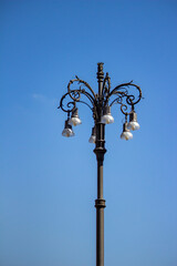 Fototapeta na wymiar Ornate wrought iron lamppost situated in front of a clear blue sky