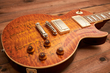 orange colored LP type guitar on dark table