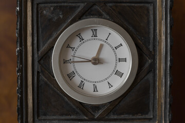 black with silver square clock with roman numerals