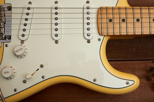 Butter colored Strat guitar on dark table
