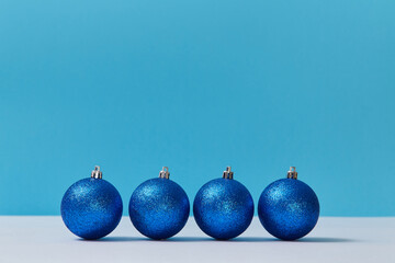Bright glitter balls for tree decor. Festive winter holiday. Happy new year. Copy space. Isolated in blue backdrop