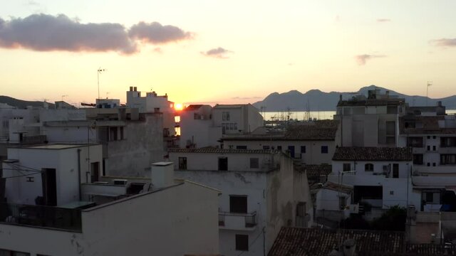 AERIAL: Small City with Port on Tropical Island with Boats and Ocean at Small Town at Sunrise with Mountains in Background Vacation, Travel, Sunset 