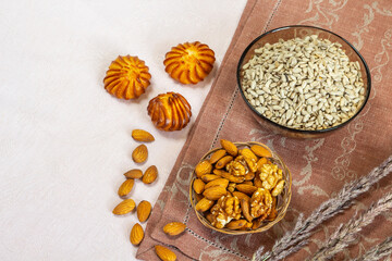 Seeds and almond nuts for breakfast.  Healthy vegetarian food.  Beige and brown linen background. Top view.