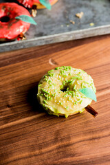 Doughnuts or donuts. Classic American favorite, apple cider donuts iced with maple syrup flavored butter cream frosting and topped with gold leaf sprinkles and decorations.
