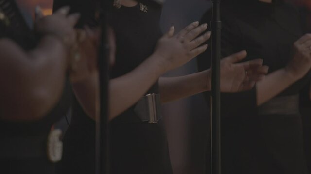 Close up of background singers clapping and dancing to music performance