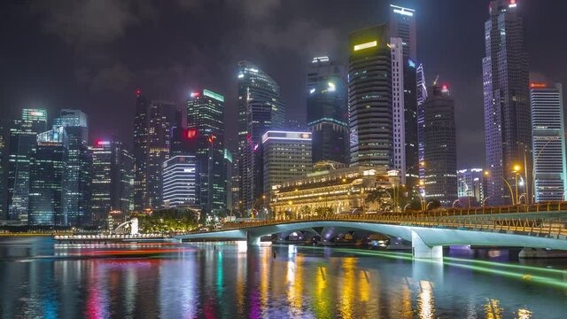 Esplanade bridge and downtown core skyscrapers in the background Singapore night timelapse hyperlapse. Illuminated towers reflected in water