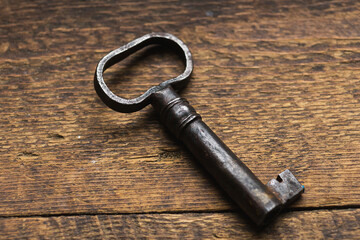 Old key on a dark wooden background.