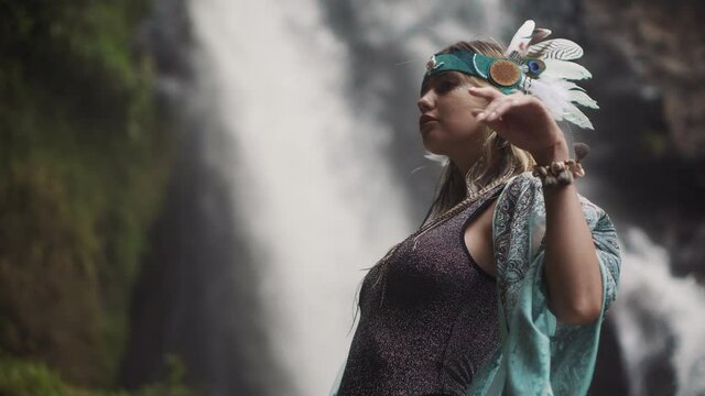 female model in image of mysterious shaman in forest with waterfall