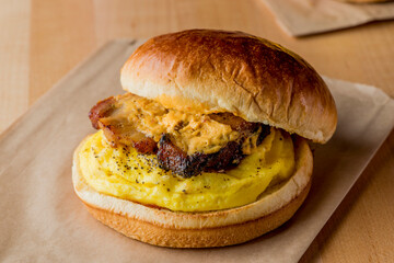 Breakfast sandwich or BLT. Toasted bread topped with eggs, sausage, bacon, ham, beef, cheese, sour cream, salsa and guacamole. Classic American restaurant or diner breakfast favorite.
