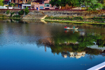 Fototapeta na wymiar Udaipur, India - May 22, 2013: A man riding a boat in one of the lake in Udaipur city of Rajasthan state