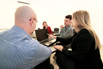 Business team meeting in their modern office. They develops business development plan and ideas. Business people working together on laptop and tablet, talk and creative communicate of next projects.