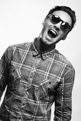 emotional studio portrait of a male brunette wearing sunglasses black and white image