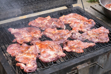 Tasty steaks on barbecue. Meat during grilling.