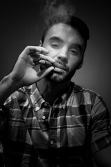 Young attractive man smokes cigar