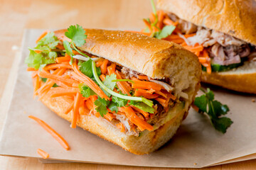 Bánh mì or banh mi, Vietnamese word for bread. Traditional classic Vietnamese cuisine. Baguette with pate, pulled pork, jalapenos, cilantro, carrots cucumbers and spicy sauce.