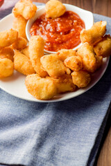 Breakfast sandwich. Bacon, fried egg, lettuce, tomato and onion on a bun being smashed by a waitresses hand. Action shot.