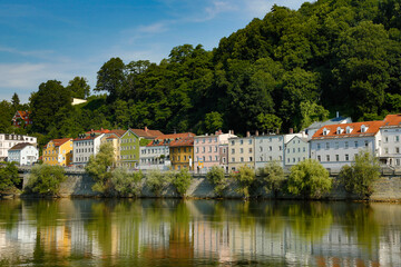 Fototapeta na wymiar Colorful apartment buildings are reflected in the Danube River near Passau Germany, Europe