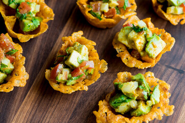 Spicy Guacamole served in crispy taco shells with salsas, cilantro and lime. Avocados diced and mixed with lemon and lime juices. Classic Tex-Mex, Mexican or American restaurant appetizer favorite.