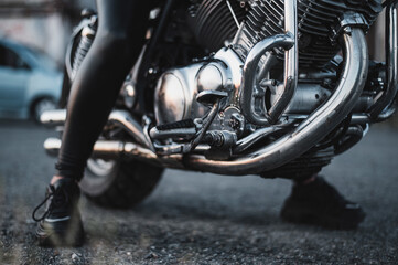 A woman in leather leggings is sitting on a motorcycle. close uo of female legs on a bike