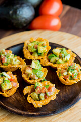 Spicy Guacamole served in crispy taco shells with salsas, cilantro and lime. Avocados diced and mixed with lemon and lime juices. Classic Tex-Mex, Mexican or American restaurant appetizer favorite.
