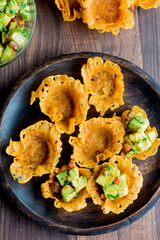 Spicy Guacamole served in crispy taco shells with salsas, cilantro and lime. Avocados diced and mixed with lemon and lime juices. Classic Tex-Mex, Mexican or American restaurant appetizer favorite.