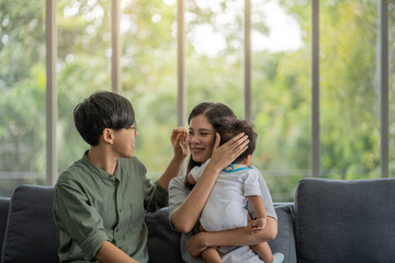 Fototapeta premium Diversity Lesbian sitting with cute toddler girl in between. Happiness and family bonding in LGBTQ family, LGBT lifestyle.