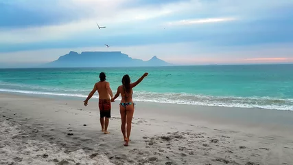 Crédence de cuisine en verre imprimé Montagne de la Table Young couple strolling on Cape Town beaches: Bloubergstrand and the view from Table Mountain