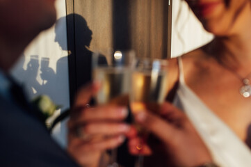 Bride and groom hold in their hands glasses with wine