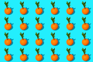 Fondo de naranjas con hojas verdes sobre fondo azul