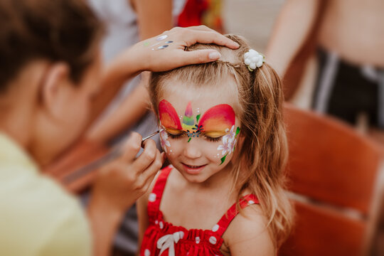 Portrait of young girl with face-painting like a unicorn.