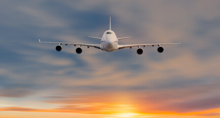 White passenger airplane in the clouds at sunset - Travel by air transport