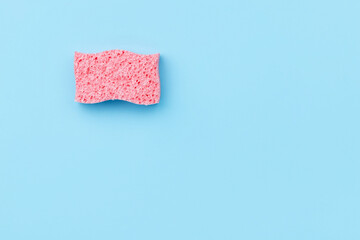 Creative layout with sponge for dishwashing on blue background.