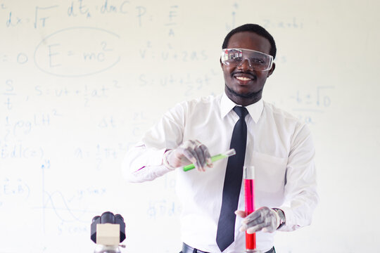 Science african teacher standing in front of blackboard teaching student in classroom - Powered by Adobe