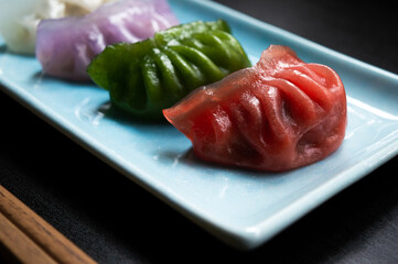 colorful chinese dumplings on a black surface