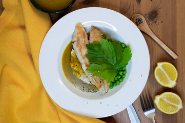 grilled fish fillet on rice with yellow napkin on wooden table