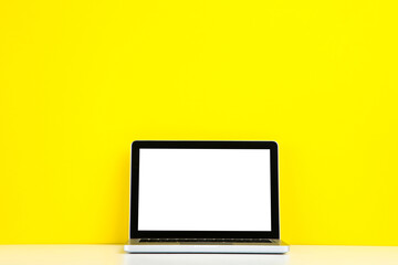 Laptop computer on yellow background